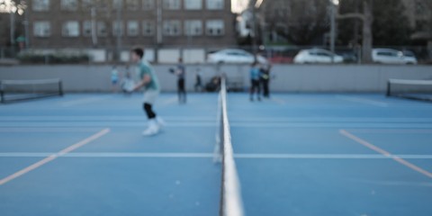 A blurred image of pickleball players on a court