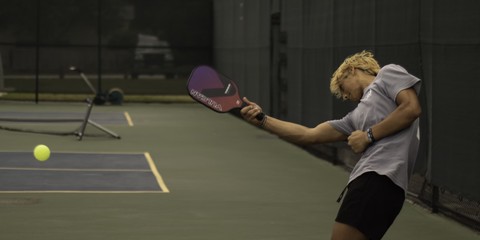 A woman hitting a pickleball return shot